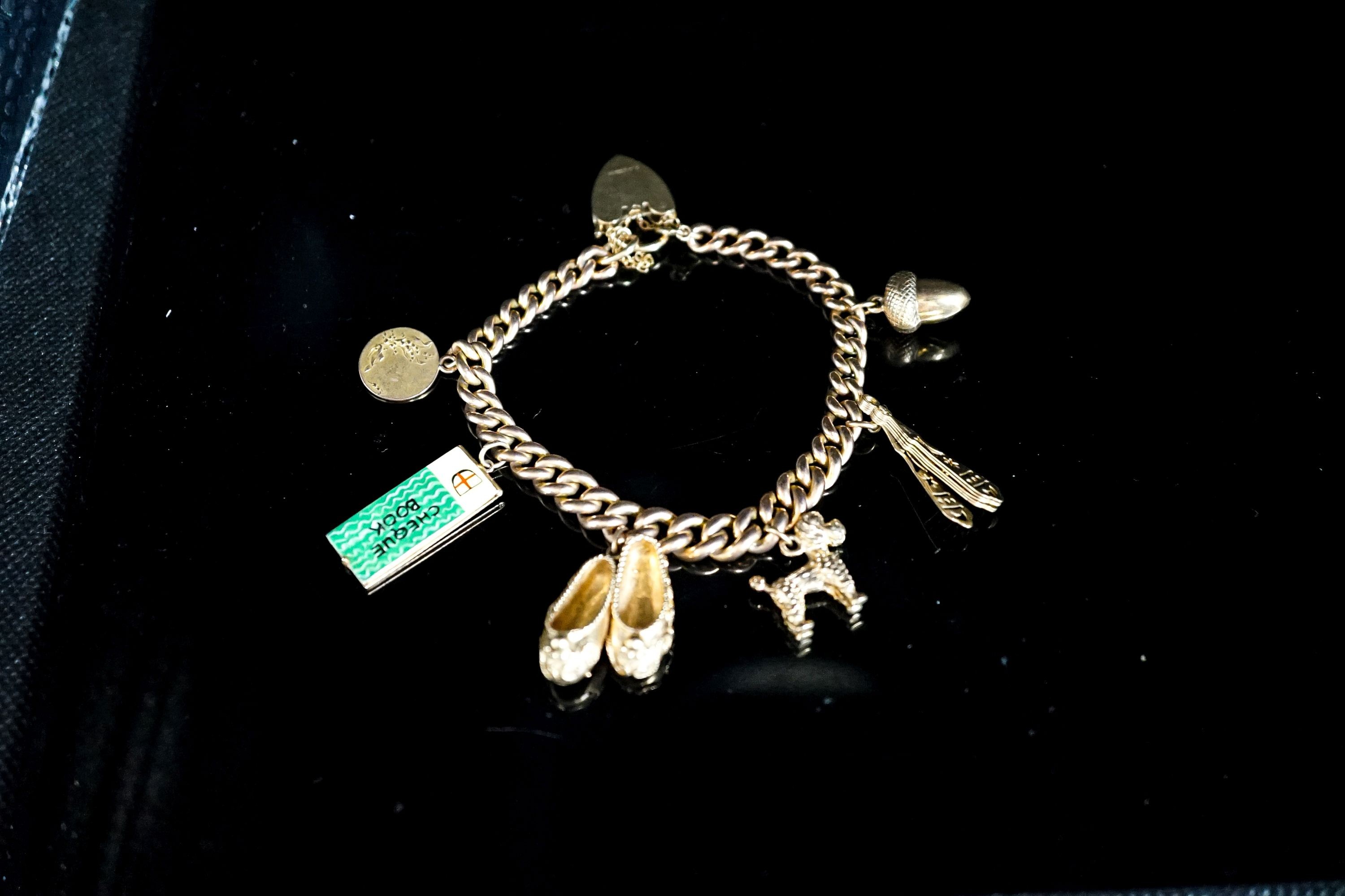 A 9ct curb link charm bracelet, hung with seven assorted charms, gross weight 38.8 grams.